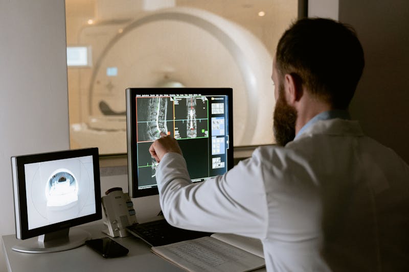 Medico revisando resultados de tomografia computarizada - Photo by MART PRODUCTION on Pexels